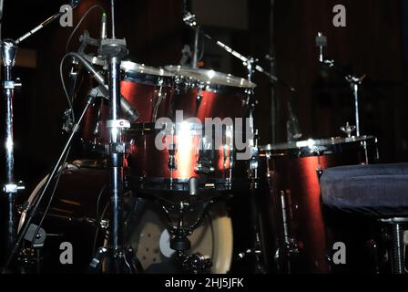 Set di tamburi sul palco, sfondo nero Foto Stock