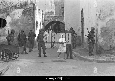 La crisi di Bizerte 1961French soldati per le strade di Bizerte . Luglio 21st 1961 la crisi è sorta dopo che le forze tunisine hanno circondato e bloccato la base navale francese a Bizzerte nella speranza di costringere la Francia ad abbandonare le sue ultime partecipazioni nel paese. Dopo che la Tunisia ha messo in guardia la Francia contro qualsiasi violazione dello spazio aereo tunisino, i francesi hanno inviato un elicottero alle truppe tunisine rispondendo lanciando colpi di avvertimento. In risposta al blocco, sono stati inviati 800 paracadutisti francesi. Mentre i paracadutisti sbarcarono sul campo aereo, le truppe tunisine li spruzzarono con un fuoco di mitragliatrici. I francesi hanno risposto con ai Foto Stock