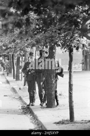 Inizio della costruzione del Muro di Berlino.a mezzanotte il 13th agosto la polizia e le unità dell'esercito tedesco orientale iniziarono a chiudere il confine e, entro domenica mattina, il 13 agosto, il confine con Berlino Ovest fu chiuso. Le truppe e i lavoratori della Germania orientale avevano iniziato a strappare le strade che costeggiano il confine per renderle impraticabili alla maggior parte dei veicoli e per installare intralci di filo spinato e recinzioni lungo i 156 chilometri intorno ai tre settori occidentali, nonché i 43 chilometri che dividono ovest ed est Berlino. Foto mostra: Le guardie di frontiera della Germania orientale tengono sotto controllo le strade di Berl Foto Stock