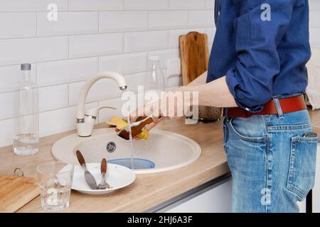 Primo piano di lavaggio dei piatti dopo la cottura a casa Foto Stock