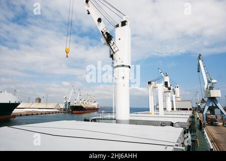 Il cantiere non dorme mai. Una foto di un porto con navi ancorate con gru. Foto Stock