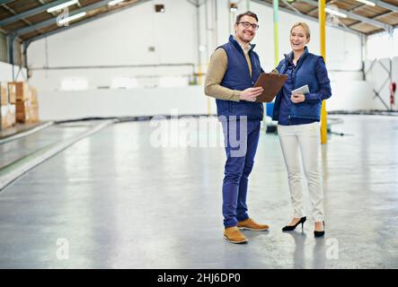 Pulizia del pavimento del magazzino. Ritratto di due floor manager che lavorano in un grande magazzino. Foto Stock