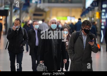 Pendolari alla stazione di Waterloo, Londra, in quanto le misure del piano B sono abolite in Inghilterra. Le coperture facciali non saranno più obbligatorie in nessun ambiente e il Pass NHS Covid non sarà più obbligatorio per l'ingresso nei locali notturni e in altri luoghi di grandi dimensioni. Data foto: Giovedì 27 gennaio 2022. Foto Stock