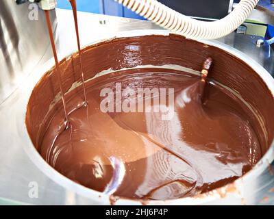 Preparazione del cioccolato liquido in vasca presso la fabbrica di dolciumi Foto Stock
