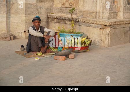 Vecchio uomo che vende mais al banco in una zona turistica. Un venditore di strada indiano che vende mais arrostito dalla strada. Udaipur India - Giugno 2020 MKP Foto Stock