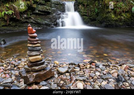 Stack di pietre bilanciate con uno splendido sfondo a cascata. Rocce impilate bilanciamento art. Ambiente, ecosistema impatto concetto. Brecon Beacons, Galles, Regno Unito Foto Stock