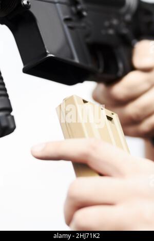 Ricarica del fucile. Primo piano sulla mano di un soldato che ricarica le munizioni in una pistola. Foto Stock