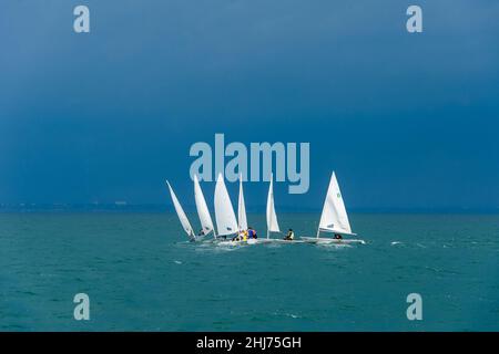 Piccole barche a vela in mare nuvoloso giorno d'estate, formazione di scuola di vela Foto Stock