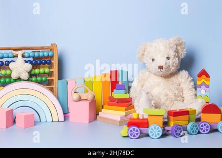 Collezione di giocattoli per bambini isolata su sfondo blu. Set di orsacchiotto e giocattolo educativo in legno per bambini. Giocattoli Montessori. Giochi musicali, logici, sensoriali per Foto Stock