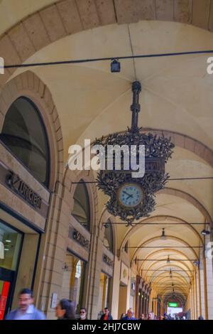 Ottobre 2021 Bologna, Italia: L'orologio l'orologio Liberty in strada via Ugo Bassi attraverso la galleria e la gente a piedi Foto Stock