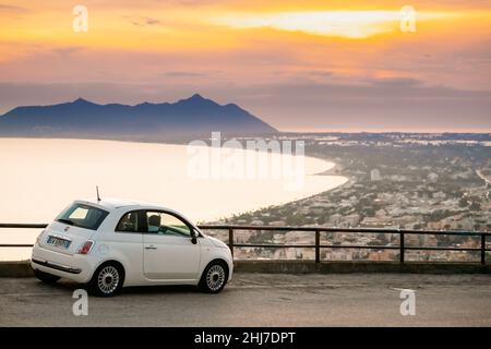 Terracina, Italia. Bianco Fiat 500 Facelift 2016 Auto parcheggiata su sfondo promontorio Circeo e Mar Tirreno in Sunset o Sunrise Time Foto Stock
