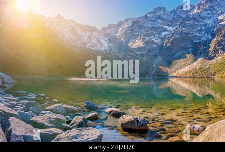 Splendida vista sul lago di montagna all'alba sui monti Tatra. Nebbia mattutina sul lago nel Parco Nazionale Polacco Tatra. Gamma di montagna in Foto Stock