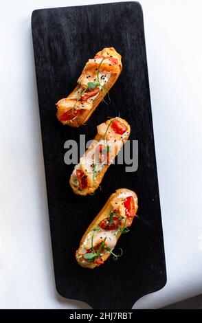 Eclairs con salmone, verdure fresche ed erbe aromatiche, spuntini gourmet. Foto Stock