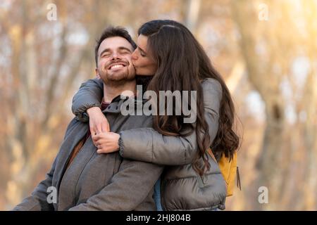 Giovane coppia eterosessuale bacia in un parco il giorno di San Valentino Foto Stock