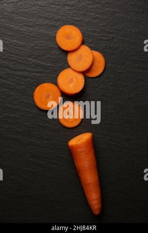 concetto vegetale parecchie fette di una carota che sono poste sullo sfondo nero. Foto Stock