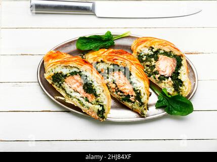 Gustoso rotolo con salmone, riso e spinaci. Torta di pesce. wellington pesce Foto Stock