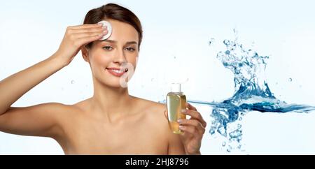 giovane donna con toner o detergente e tampone di cotone Foto Stock