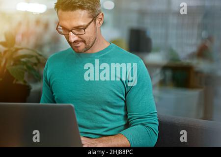 Lavorare diligentemente. Scatto corto di un uomo d'affari che lavora sul suo laptop. Foto Stock