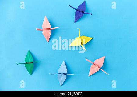 la carta origami si gru su sfondo blu Foto Stock