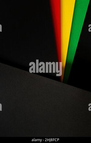 Nero Storia mese colore sfondo. Festa del mese della storia afro-americana. Bandiera astratta di colore rosso, giallo, verde su sfondo di carta nero Foto Stock