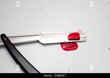 Gocce di sangue su un rasoio dritto. Foto Stock