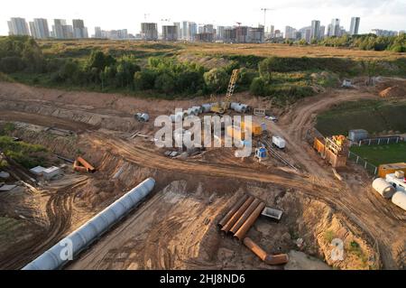 Tubi fognari in calcestruzzo per la posa di sistemi fognari esterni in cantiere. Alesatrice a tunnel in collettore fognario per costruzioni sotterranee Foto Stock