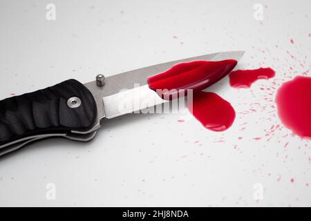 Gocce di sangue su un coltello pieghevole. Foto Stock