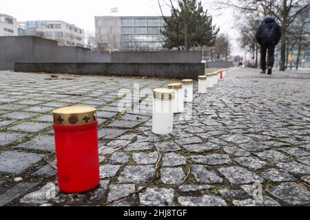 Berlino, gennaio 27. 27th Jan 1945. Un pedone cammina accanto alle candele poste al Memoriale degli ebrei d'Europa assassinati a Berlino, in Germania, il 27 gennaio 2022. Il Bundestag tedesco ha tenuto giovedì una cerimonia che segna il 77th° anniversario della liberazione del campo di concentramento di Auschwitz il 27 gennaio 1945. Credit: Shan Yuqi/Xinhua/Alamy Live News Foto Stock