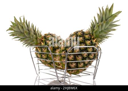 Due ananas dolci e biologici in un cesto, primo piano, isolato su bianco. Foto Stock