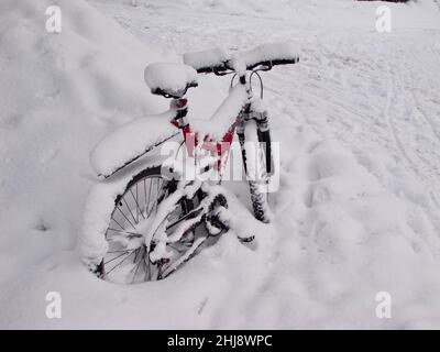 La bicicletta è parcheggiata all'aperto accanto a una fermata dell'autobus e in inverno diventa coperta di neve. Foto Stock