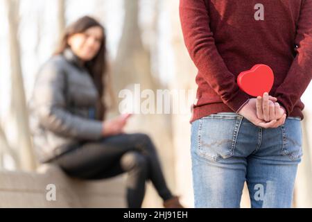 L'uomo sorprende la sua ragazza con un regalo a forma di cuore Foto Stock