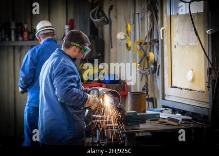 Rettifica di taglio di un tubo in un'officina Foto Stock