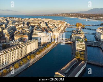 Vista aerea del fiume Rodano nel cuore del centro storico di Ginevra e del quartiere degli affari prima di raggiungere il lago di Ginevra in Svizzera in una soleggiata giornata autunnale Foto Stock