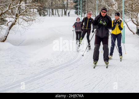 Vacanze invernali attive. Persone di diverse età, donne e uomini, sciare sulla pista da sci in inverno il giorno di partenza. Sci di fondo Foto Stock