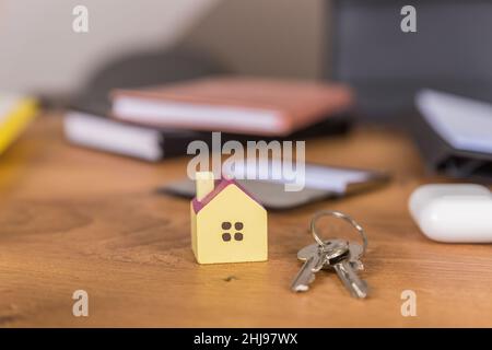 Disposizione portachiavi a forma di chiave e di casa su sfondo blu. Foto Stock