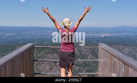 Donna con le braccia sollevate contemplando la vista da un punto di vista del fiume Sil. Foto Stock