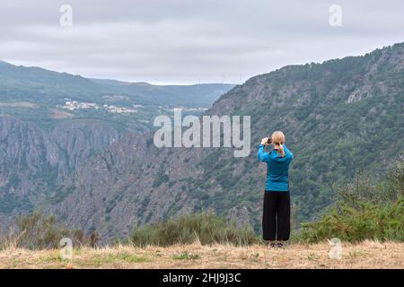 Donna sulla schiena scattando una foto del canyon del Sil. Foto Stock