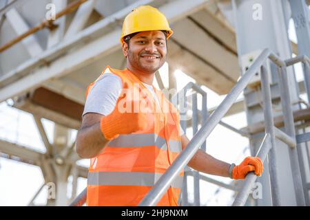 Sorridente giovane uomo che lavora in cantiere Foto Stock