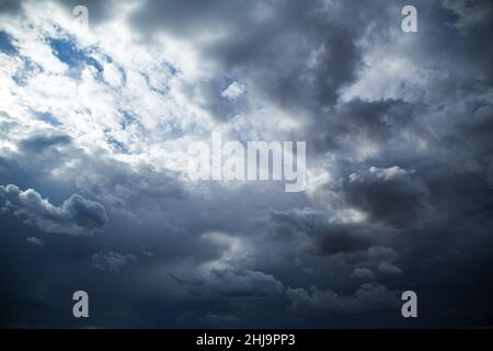 Spettacolari nuvole di pioggia scure e nuvole nel cielo con un piccolo angolo di luce del sole. Foto Stock