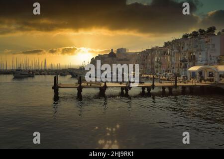 Bella alba che illumina le case colorate del porto di Procida Foto Stock