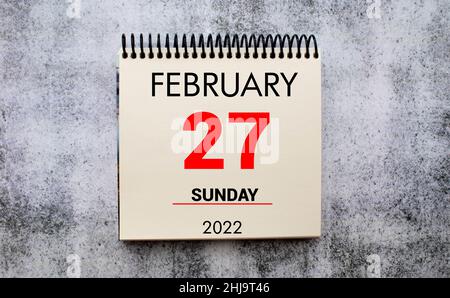 febbraio 27. 27th giorno del mese, data di calendario. Supporto per calendario da tavolo su sfondo beige in legno. Concetto di giorno dell'anno, pianificatore di tempo, Winter mon Foto Stock