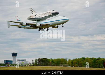 Space Shuttle Discovery è trasportato da Boeing Model 747-100 NASA Shuttle Carrier Aircraft, in volo sul Naval Air and Space Museum a Washington, DC, USA, 17 aprile 2012 Foto Stock