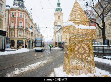 Graz, Austria-09 dicembre 2021: Herrengasse strada dopo una neve pesante con traffico pesante e belle decorazioni natalizie, nel centro della città di G. Foto Stock
