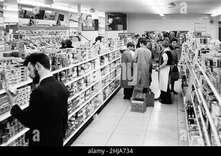 Shoppers, fine fare Supermarket, Wilton, Londra, 29th ottobre 1963. Corridoio di shopping, merci su scaffali. Shop Assistants, scaffali di impilamento. Foto Stock