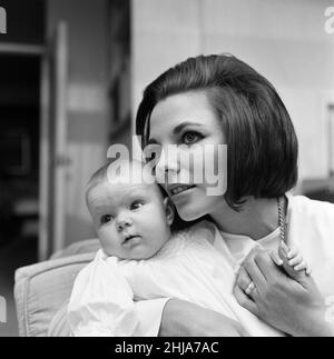 Joan Collins ha ritratto con la sua figlia di quattro mesi Tara Newley. Sono venuti a casa a Londra per vedere la famiglia. Qui sono oggi dopo che la mamma è stata negli studi cinematografici e il bambino Tara si è svegliato dopo il suo sonno. 20th febbraio 1964. Foto Stock