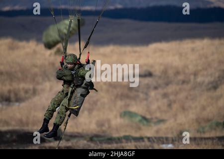 Un paratrooper della forza di autodifesa del suolo giapponese assegnato alle 1st Brigade aeree atterra sulla zona di goccia al campo di addestramento combinato di armi Fuji, Giappone, durante Airborne 22, 25 gennaio 2022. Il salto ha messo in evidenza la capacità tra l'aeronautica statunitense e la capacità di JGSDF di dispiegare rapidamente forze congiunte, con l'addestramento che sottolinea il forte impegno alleato verso una regione indopacifica libera e aperta. (STATI UNITI Air Force foto di Senior Airman Brieana E. Bolfing) Foto Stock