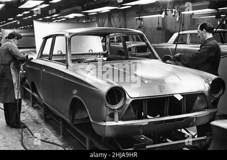 Scene generali all'interno della fabbrica di motori Ford a Dagenham, Essex, che mostrano vetture sulla linea di produzione. 24th gennaio 1964. Foto Stock