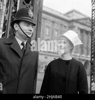 Quando Dorothy Provine 'rosa' arrivò oggi a Londra, voleva vedere la città e fare un po' di gommoni alle famose attrazioni turistiche. L'attrice americana chiacchiera con un poliziotto fuori da Buckingham Palace. 22nd maggio 1962. Foto Stock