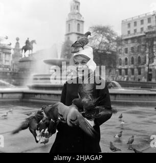 Quando Dorothy Provine 'rosa' arrivò oggi a Londra, voleva vedere la città e fare un po' di gommoni alle famose attrazioni turistiche. L'attrice americana era più che accolta dai piccioni in Trafalgar Square. 22nd maggio 1962. Foto Stock