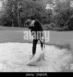 Filmare la scena del golf per 'Goldfinger' al campo da golf di Stoke Park vicino Stoke Poges, Buckinghamshire, sono stati Sean Connery ( James Bond ) Gert Frobe ( Goldfinger ) e Harold T Sakata che è meglio conosciuto come ' Tosh Togo ' nel mondo di Wrestling. Harold sta giocando la parte del caddy per questa scena. Nel film James Bond e Goldfinger giocano per un palo del £5000. Il gioco è storto dall'inizio alla fine, ma Bond vince alla fine Certo. 21st maggio 1964 Foto Stock